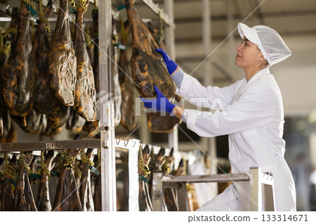 Girl employee checks jamon. Quality control 133314671