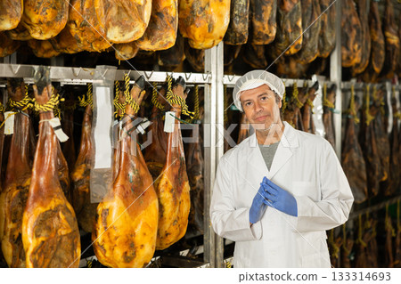 man factory employee stands against the background of jamon man factory employee stands against the background of jamon 133314693