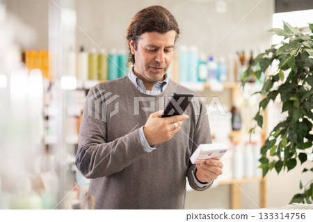 Man scans code on package of paracetamol pills to check expiration date 133314756