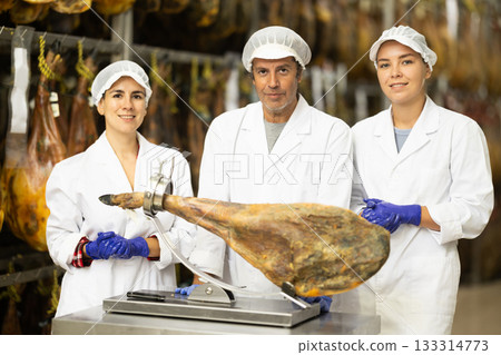 Staff of hamon manufacturing workshop presents product using jamonero Staff of hamon manufacturing workshop presents product using jamonero 133314773