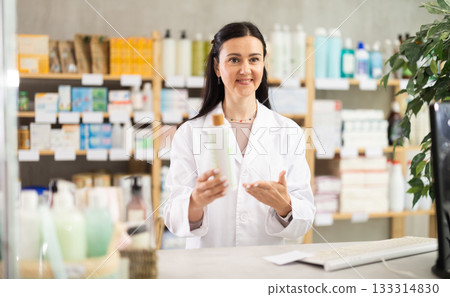 Middle-aged female pharmacist offering shampoo 133314830