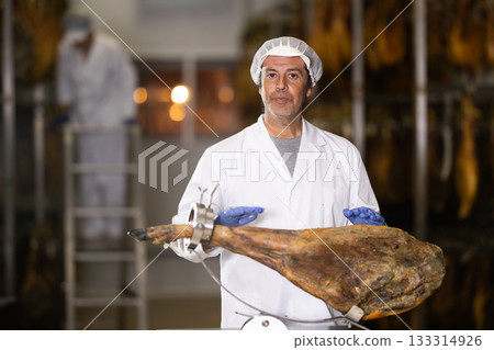 man presents jamon on a stand 133314926