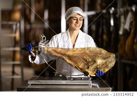 woman put the jamon on the bod and is preparing to cut 133314952