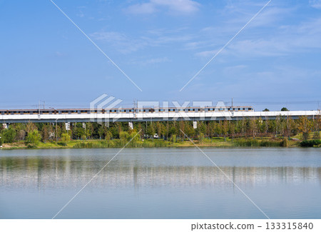 藍天白雲下的軌道列車與水中的倒影 藍天白雲下的軌道列車與水中的倒影 133315840