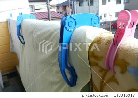 On a nice, sunny morning, hang your futon out on the balcony and make sure to secure it with futon clips. 133316018