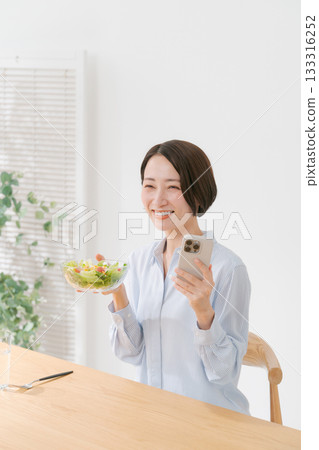 A woman with a smartphone and salad 133316252