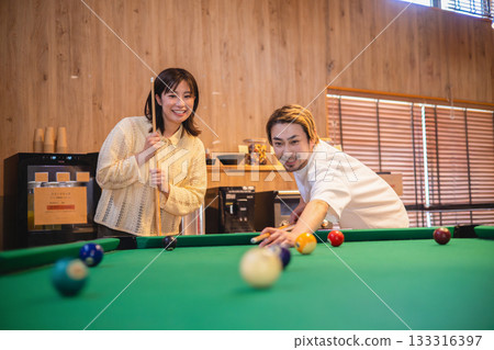 Couple playing billiards Couple playing billiards 133316397