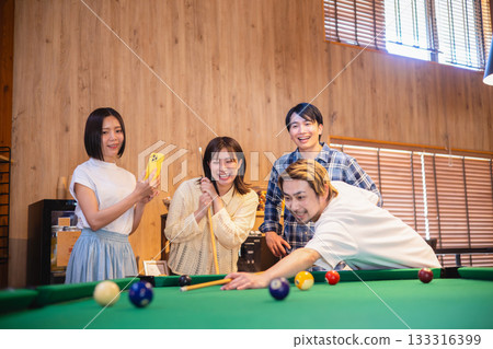 Friends enjoying billiards 133316399