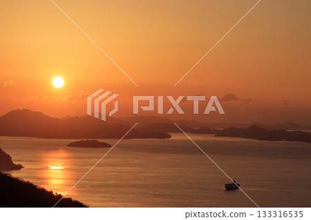 The sun rising from the islands of the Seto Inland Sea, dyed in the morning glow The sun rising from the islands of the Seto Inland Sea, dyed in the morning glow 133316535