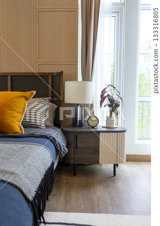 Interior of yellow and blue pillow on cozy modern bedroom with carpet and side table lamp. 133316805