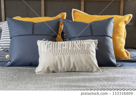Interior of yellow and blue pillow on cozy modern bedroom with carpet and side table lamp. 133316809