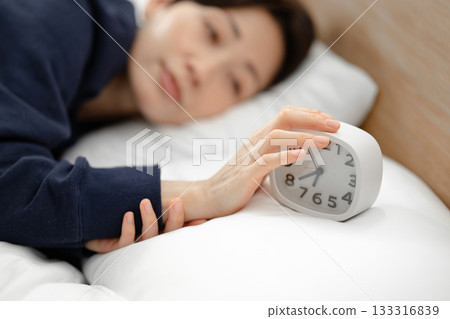 Woman sleeping in bed, alarm, oversleep Woman sleeping in bed, alarm, oversleep 133316839