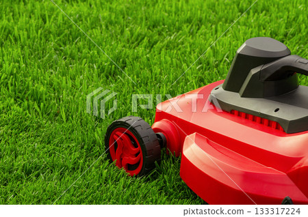 Lawn mower on a green lawn. Mowing the grass. Lawn mower on a green lawn. Mowing the grass. 133317224