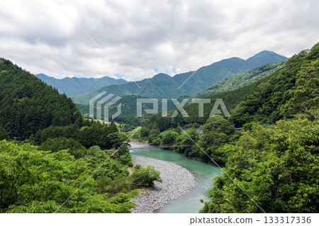A suspension bridge over the Oi River and green mountain scenery 133317336