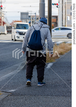 Senior walking on the sidewalk with a backpack 133317608