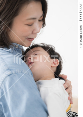 母親懷抱中哄睡嬰兒-高齡母親教養子女、出生率下降和單親家庭的畫面 母親懷抱中哄睡嬰兒-高齡母親教養子女、出生率下降和單親家庭的畫面 133317828