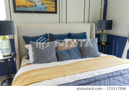 Interior of modern spacious master bedroom with big bed under a wall decoration and brown carpet. Interior of modern spacious master bedroom with big bed under a wall decoration and brown carpet. 133317896