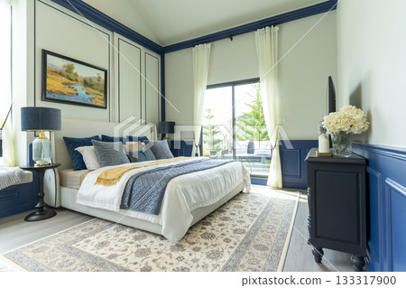 Interior of modern spacious master bedroom with big bed under a wall decoration and brown carpet. Interior of modern spacious master bedroom with big bed under a wall decoration and brown carpet. 133317900
