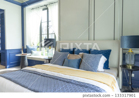 Interior of modern spacious master bedroom with big bed under a wall decoration and brown carpet. Interior of modern spacious master bedroom with big bed under a wall decoration and brown carpet. 133317901