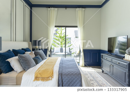 Interior of modern spacious master bedroom with big bed under a wall decoration and brown carpet. Interior of modern spacious master bedroom with big bed under a wall decoration and brown carpet. 133317905