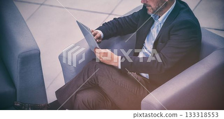 Businessman using tablet on sofa Businessman using tablet on sofa 133318553