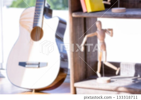Figurine on shelf by guitar near window Figurine on shelf by guitar near window 133318711
