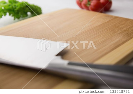 Large knife on wooden chopping board with tomatoes and parsley Large knife on wooden chopping board with tomatoes and parsley 133318751