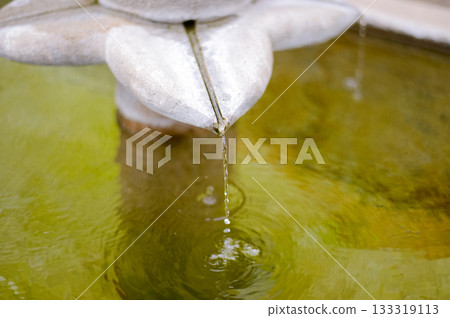 Close-up of Water Droplet Falling from Stone Fountain Sculpture with Ripples Close-up of Water Droplet Falling from Stone Fountain Sculpture with Ripples 133319113