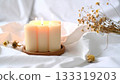 Aroma candles and dried flowers on white linen 133319203