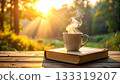 A steaming mug and a book on a natural wooden table 133319207