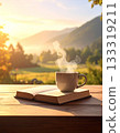 A steaming mug and a book on a natural wooden table 133319211