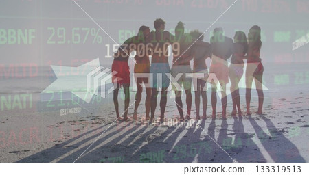 Standing eight friends in swimwear linking arms facing ocean on beach at sunset, with stock tickers 133319513