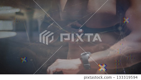 Tugging shorts strap, shirtless fitness athlete wearing fitness watch at gym, with digital overlay Tugging shorts strap, shirtless fitness athlete wearing fitness watch at gym, with digital overlay 133319594
