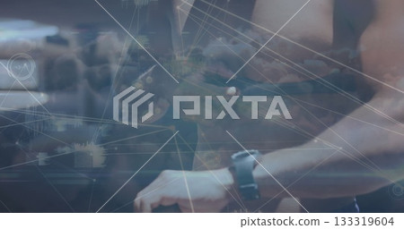 Man wearing sleeveless top checking smartphone and sport watch in stadium with network overlay 133319604