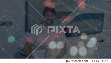 Man wearing white tee holding guitar standing in studio, with digital network overlay, bokeh spots 133319644