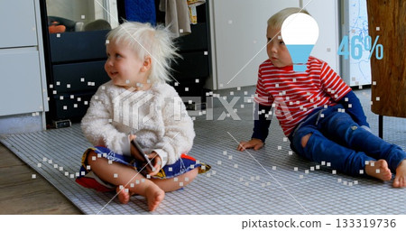 Sitting siblings using smartphone on grey grid mat in living area, with 46% light bulb icon 133319736
