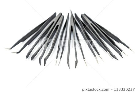 Set of black precision tweezers with metal tips arranged on white background for detailed tasks and crafts Set of black precision tweezers with metal tips arranged on white background for detailed tasks and crafts 133320237
