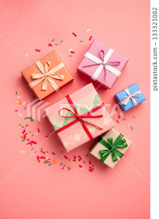 Top view of colorful gift boxes with decorative ribbons and scattered confetti on a soft pink background. Festive composition for celebrations, birthdays, holidays, and party invitations. Top view of colorful gift boxes with decorative ribbons and scattered confetti on a soft pink background. Festive composition for celebrations, birthdays, holidays, and party invitations. 133321082