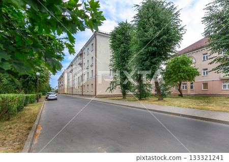 Quiet Residential Street with Apartment Buildings and Green Trees 133321241