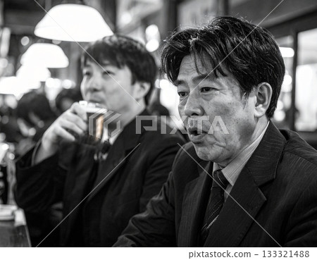 Black and white photo of a businessman drinking at an izakaya after work 133321488