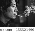 Black and white photo of a man smoking a cigarette 133321490