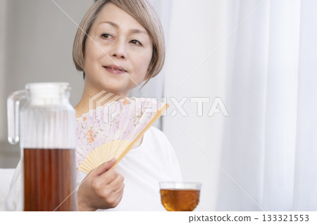 老婦人在客廳用風扇降溫 133321553