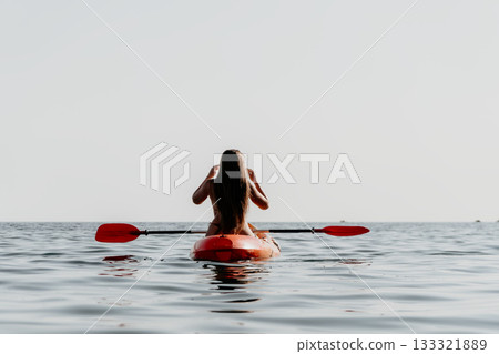 Woman Paddleboarding Ocean Summer: A woman enjoys paddleboarding on a calm ocean during a summer day. 133321889