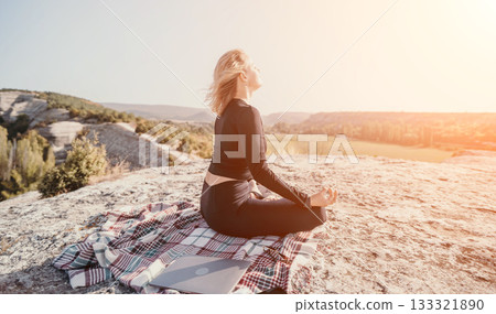 Woman Meditating on a Mountaintop with a Laptop 133321890