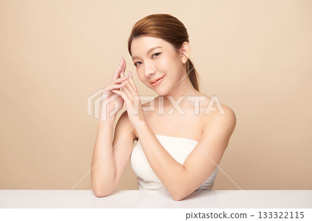 A beautiful young Asian woman with clean, fresh skin against a beige background. Skincare, facial treatment, cosmetology, beauty, and spa. An elegant portrait of an Asian woman. A beautiful young Asian woman with clean, fresh skin against a beige background. Skincare, facial treatment, cosmetology, beauty, and spa. An elegant portrait of an Asian woman. 133322115