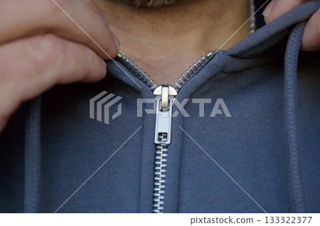 Man zipping gray hoodie close-up Man zipping gray hoodie close-up 133322377