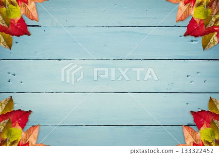 Blue wooden plank backdrop is being framed by colorful autumn leaves in flat design, copy space 133322452