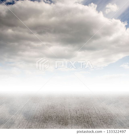 Concrete-like ground is being shown in flat illustration, with overcast sky and layered clouds 133322497
