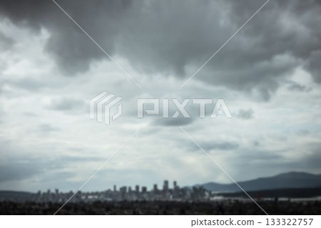 Showing flat design urban skyline stretching wide with foothill mountains under heavy clouds 133322757