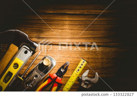 Flat design showing hand tools aligning left on wooden workbench with warm lighting, showing grain 133322827
